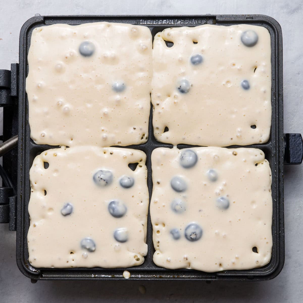 Batter in waffle iron before cooked.