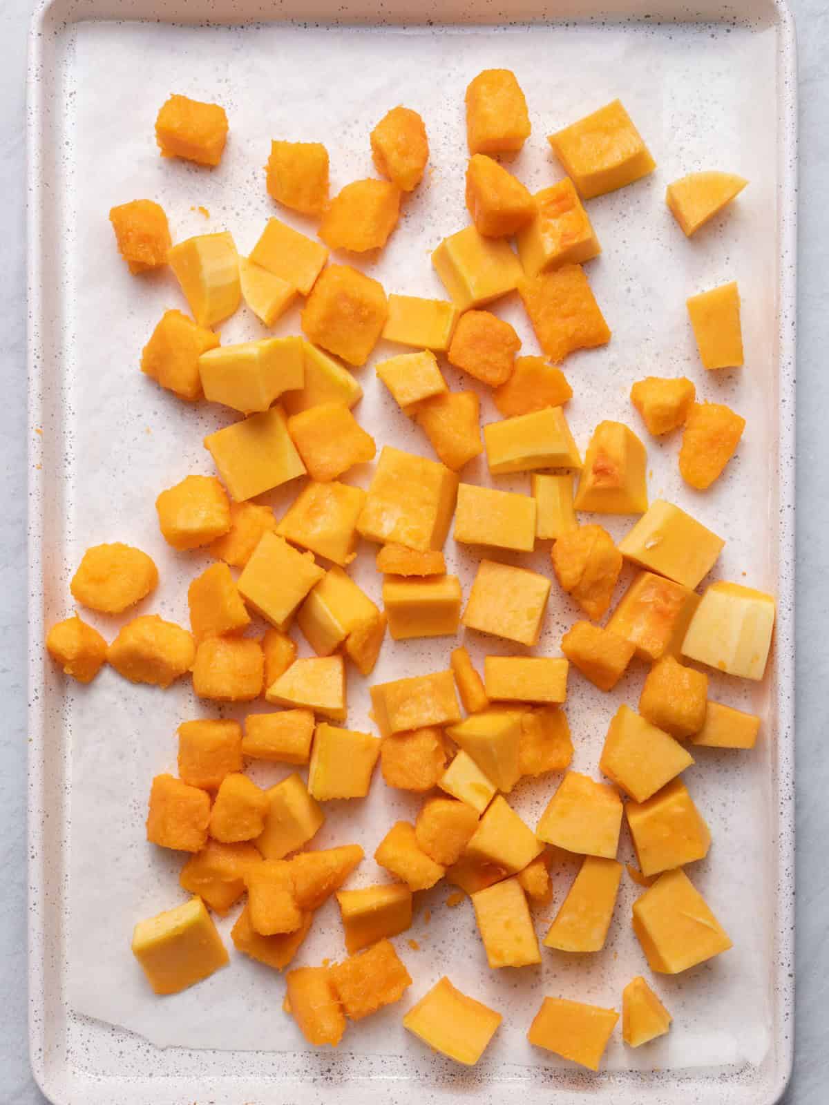 Cubed butternut squash on baking dish.