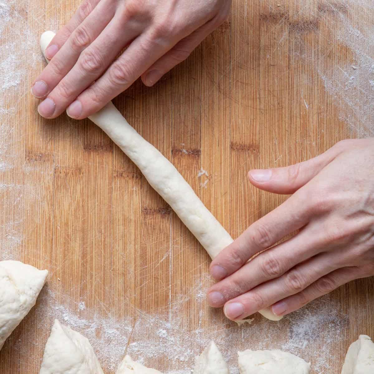 Hand rolling dough into log.