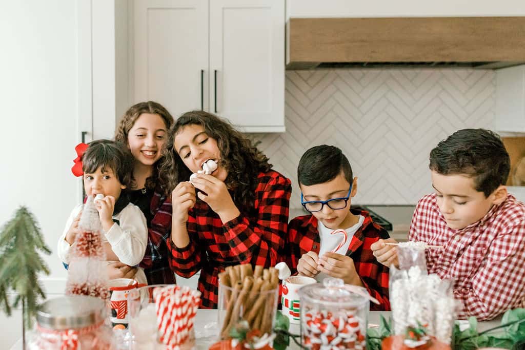 Kids enjoying hot cocoa treats on kitchen island