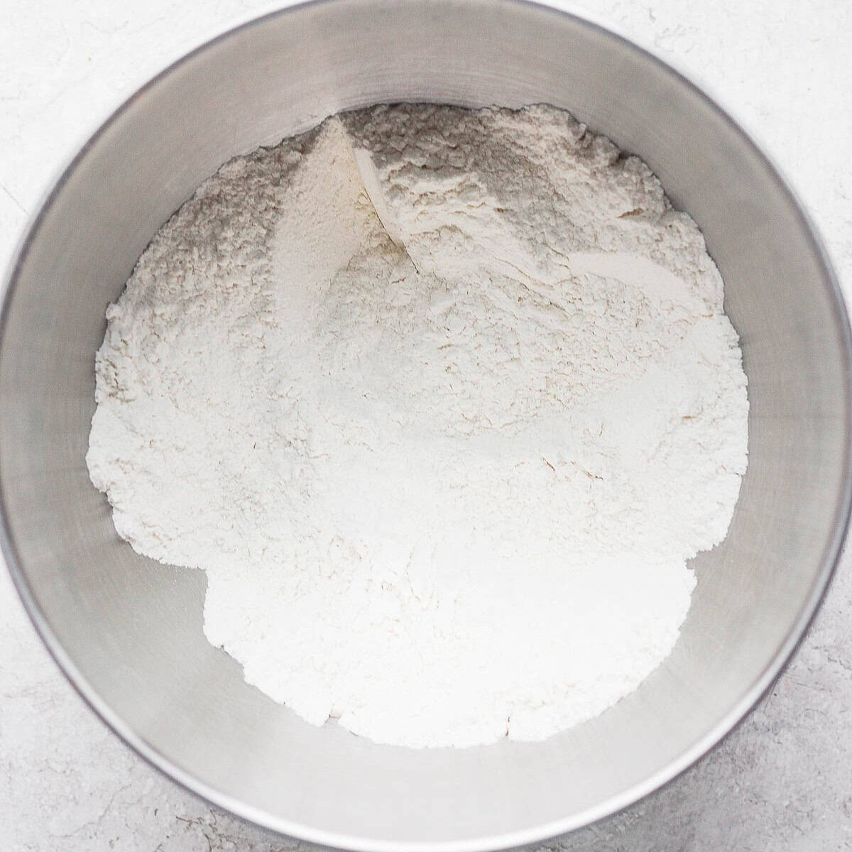 Flour, sugar and salt in bowl of food processor or mixer combined.