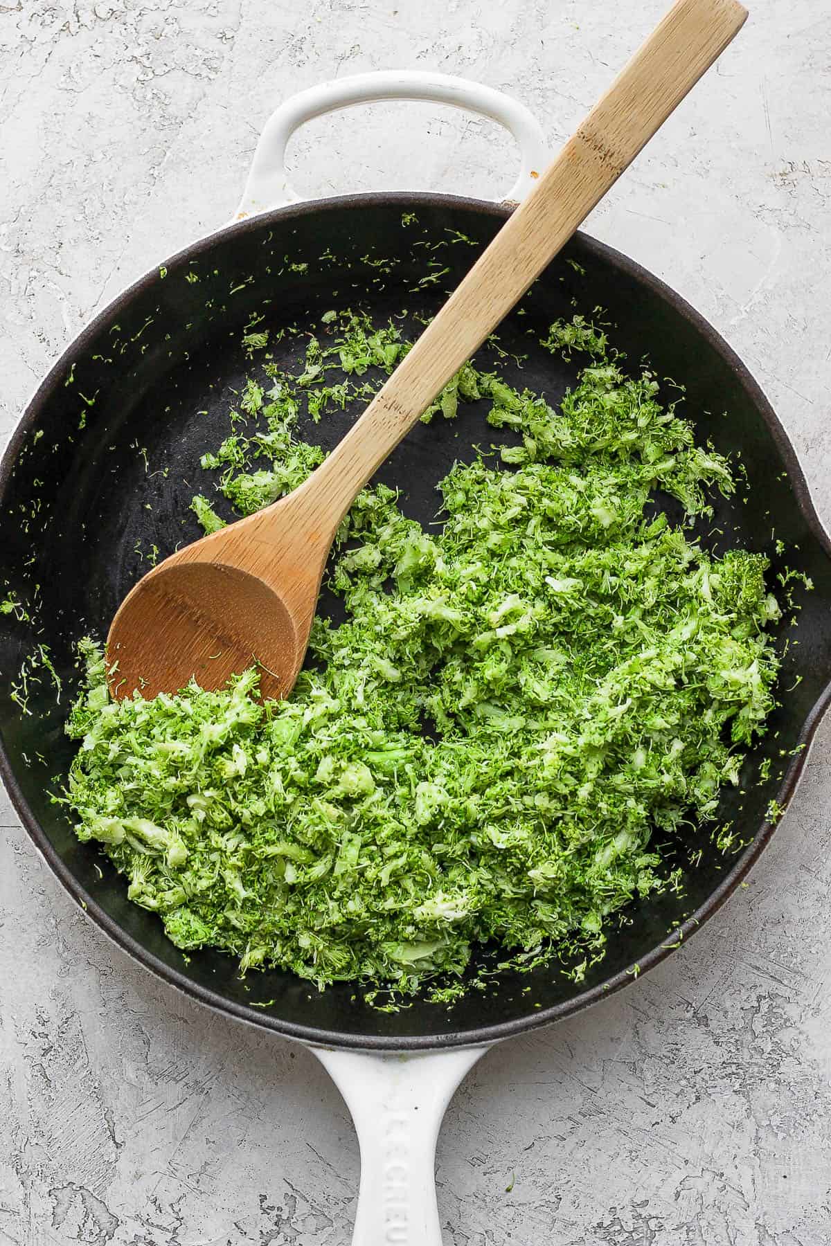 Broccoli rice in a pan with a wooden spoon