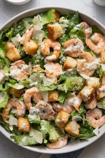 Large bowl of the salad with the dressing drizzled on top.