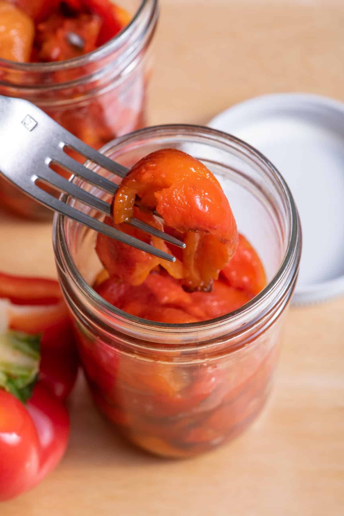 Fork lifting up roasted red bell peppers