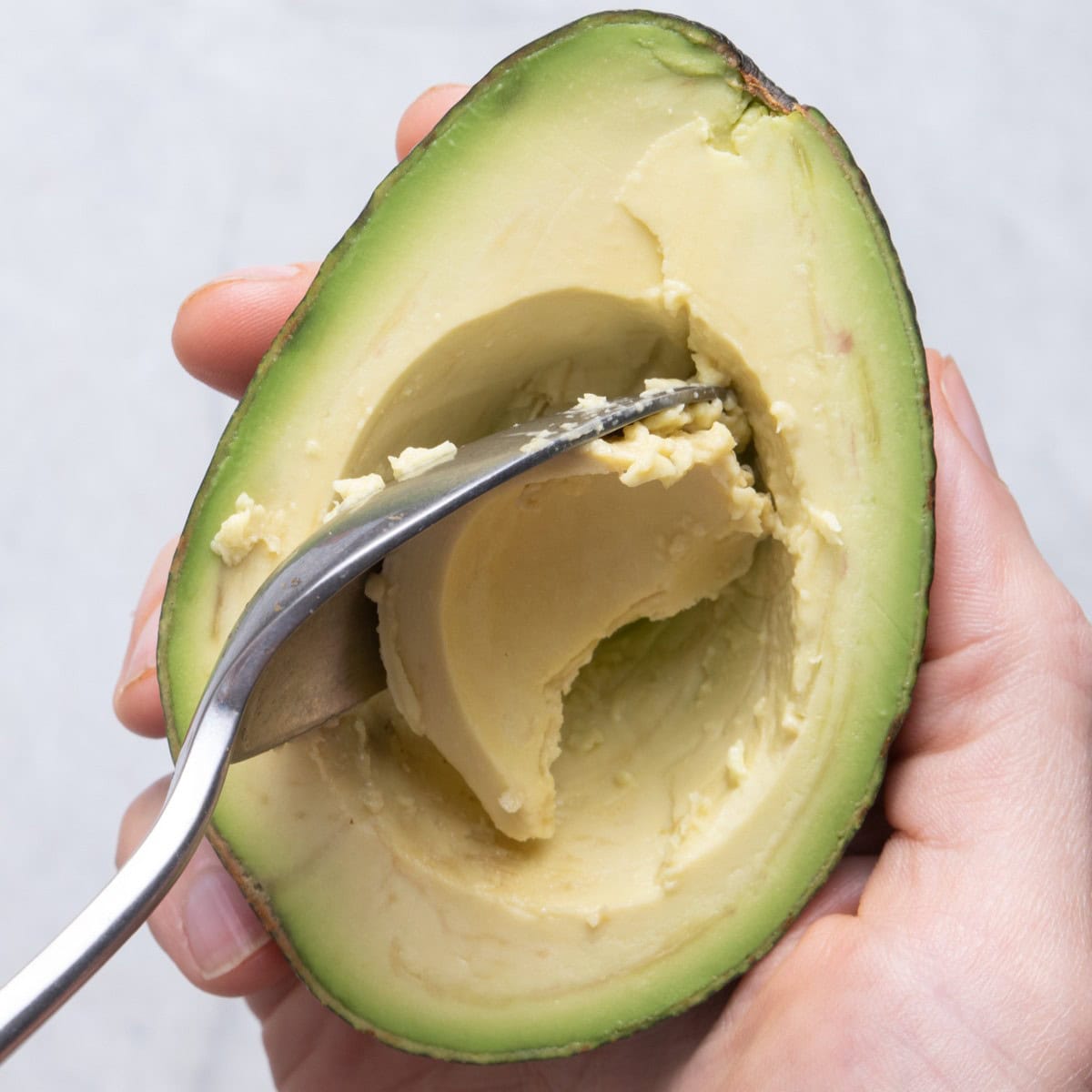 Scooping out some of the avocado.
