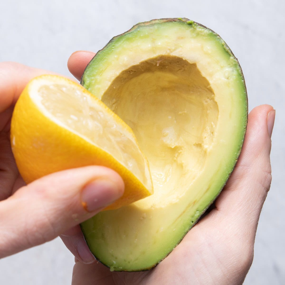 Squeezing lemon on top of avocado.