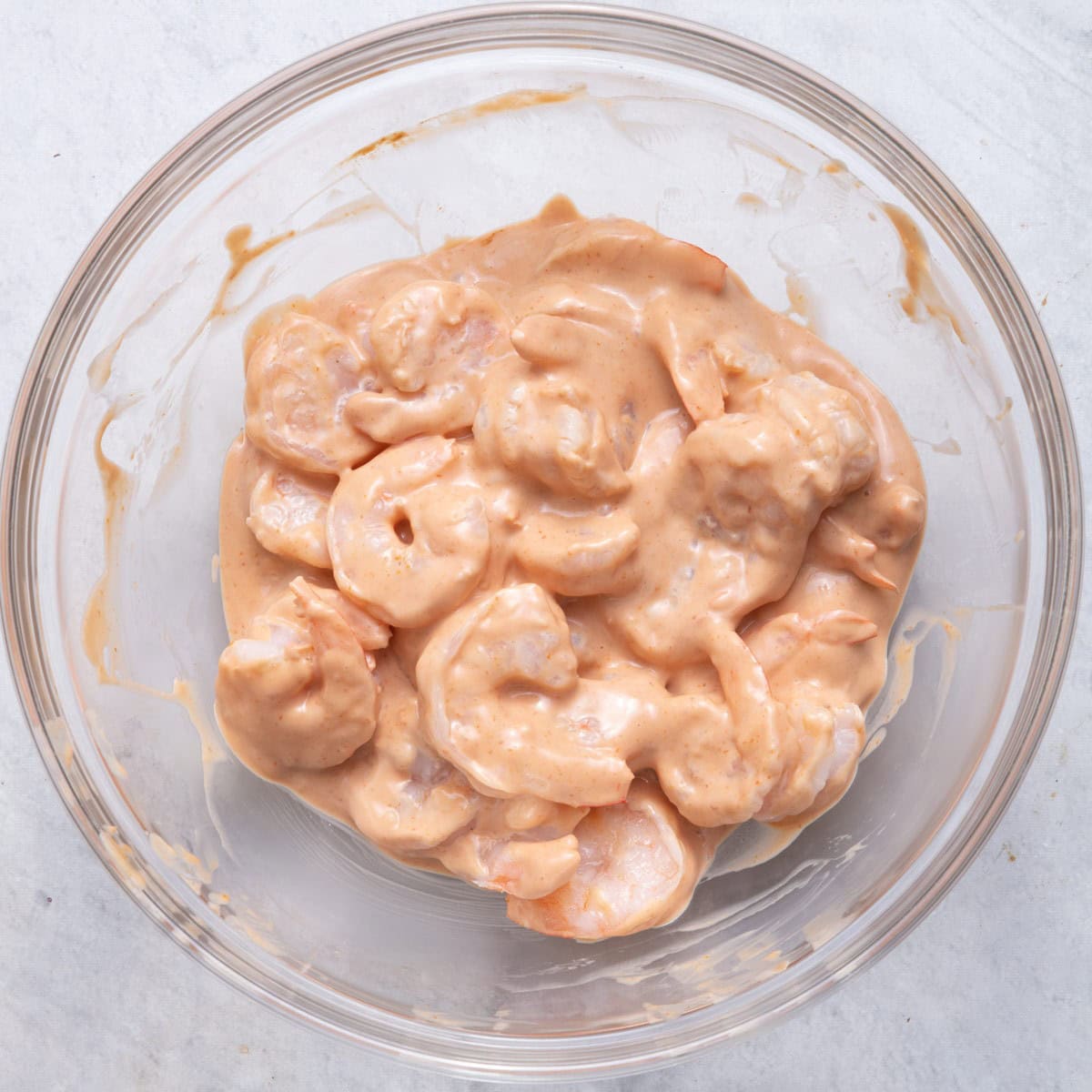 Shrimp mixed into cocktail sauce.