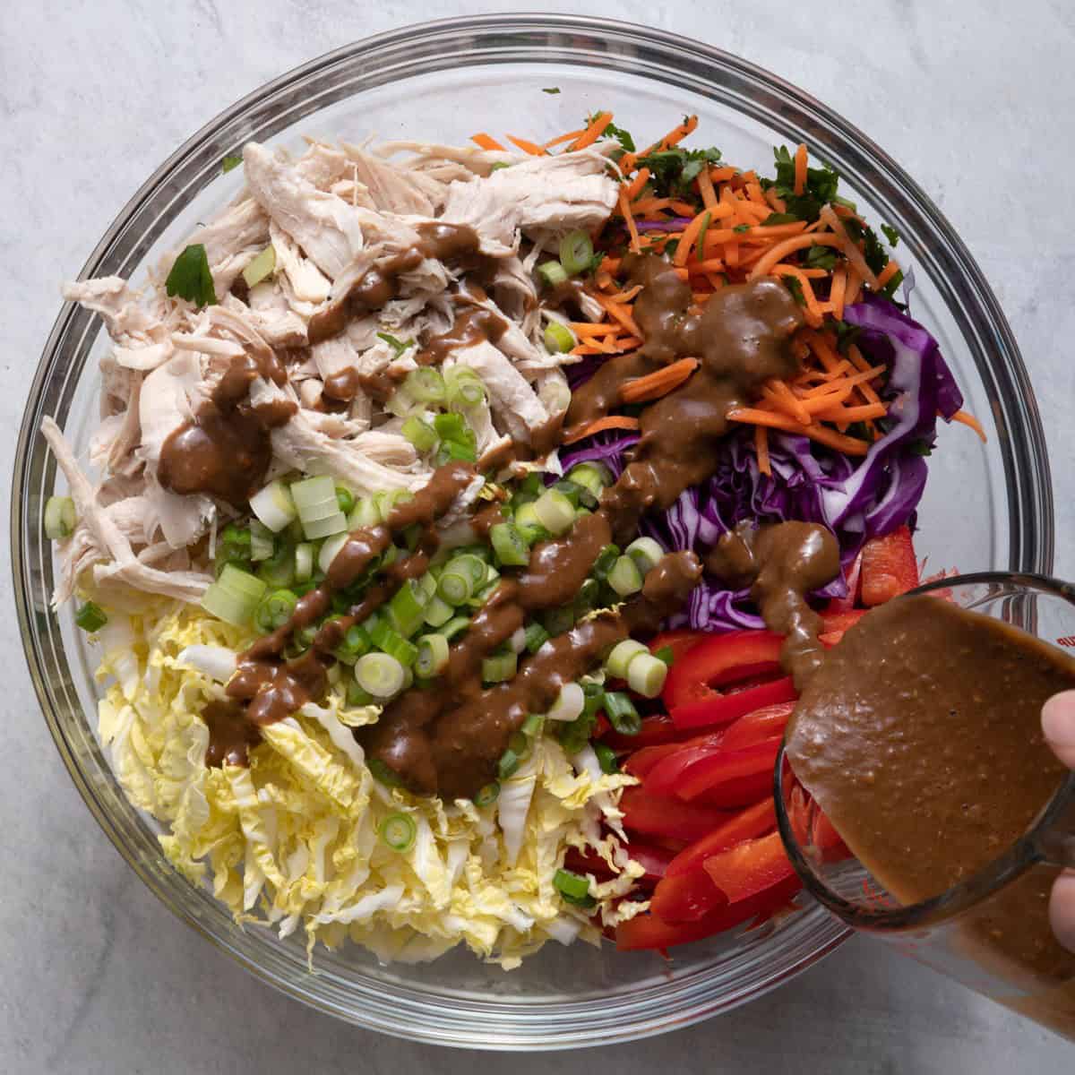 Pouring dressing on top of salad.
