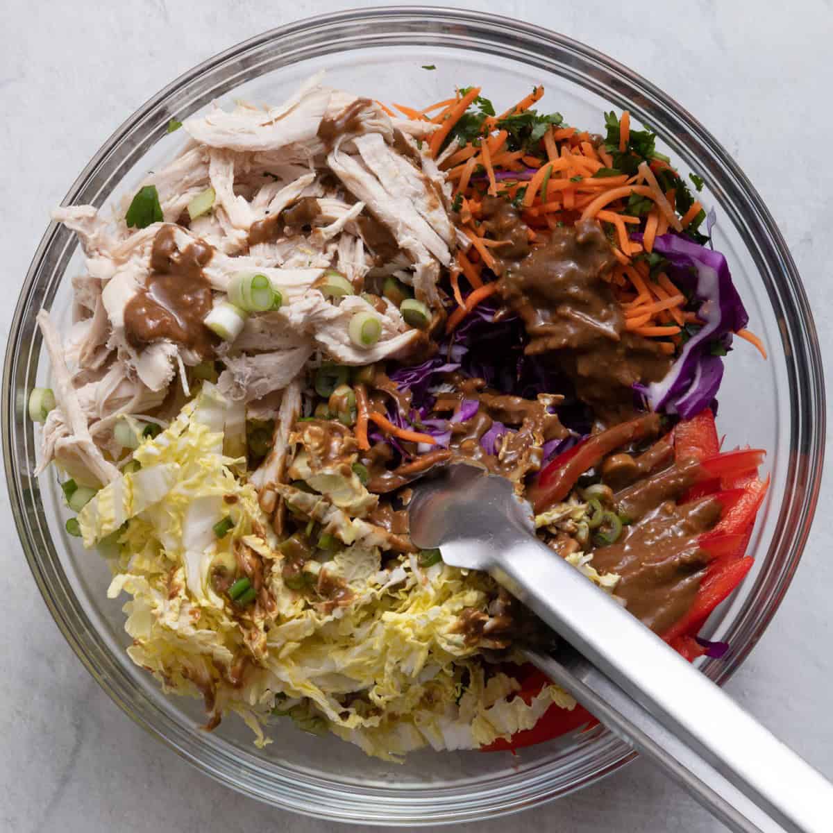 Using tongs to toss salad.