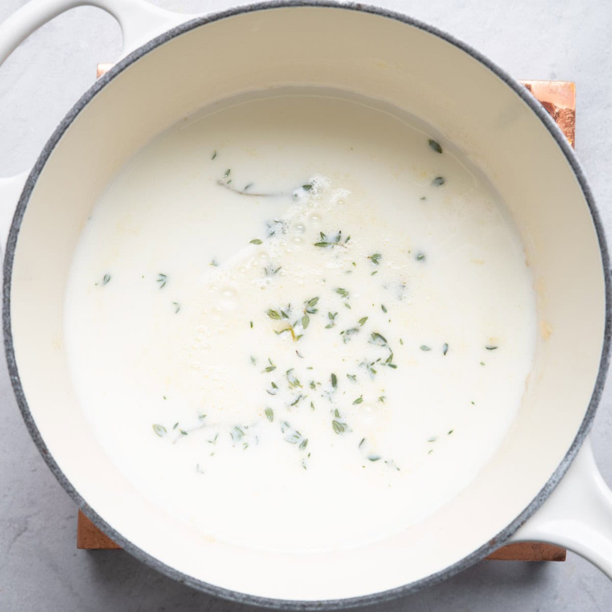 Milk and thyme added to shallots and garlic.