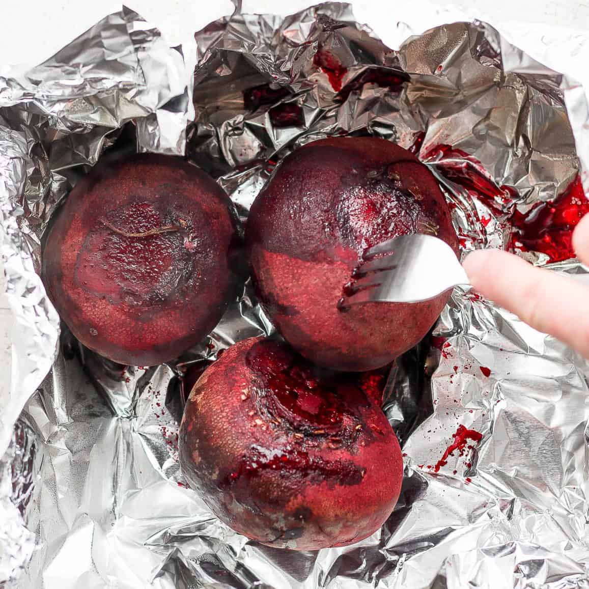 Beets after roasted with fork piercing to show tender.