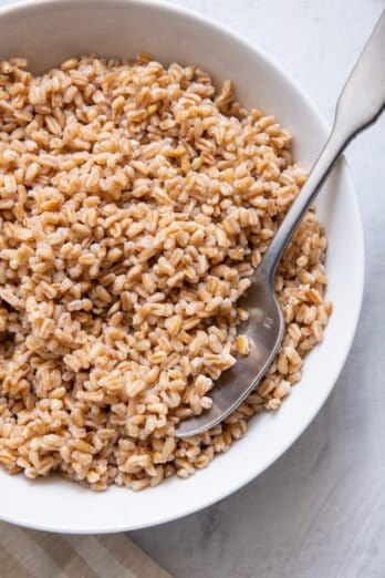 Spoon in bowl of cooked farro