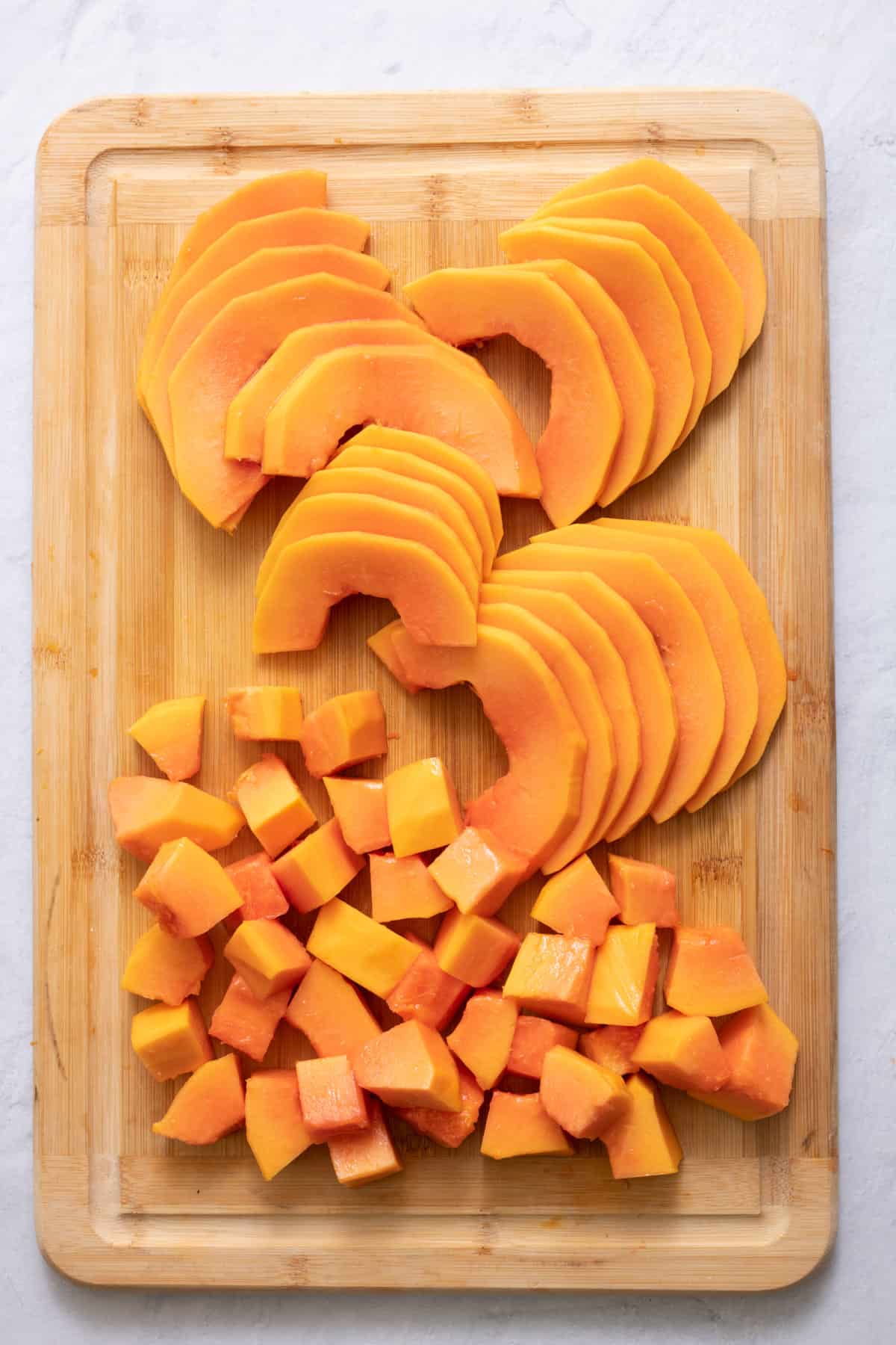 cutting board with two different ways to cut papaya