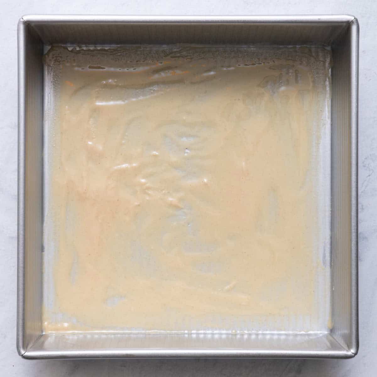 Tahini on the bottom of a baking pan before adding the cake mixture.
