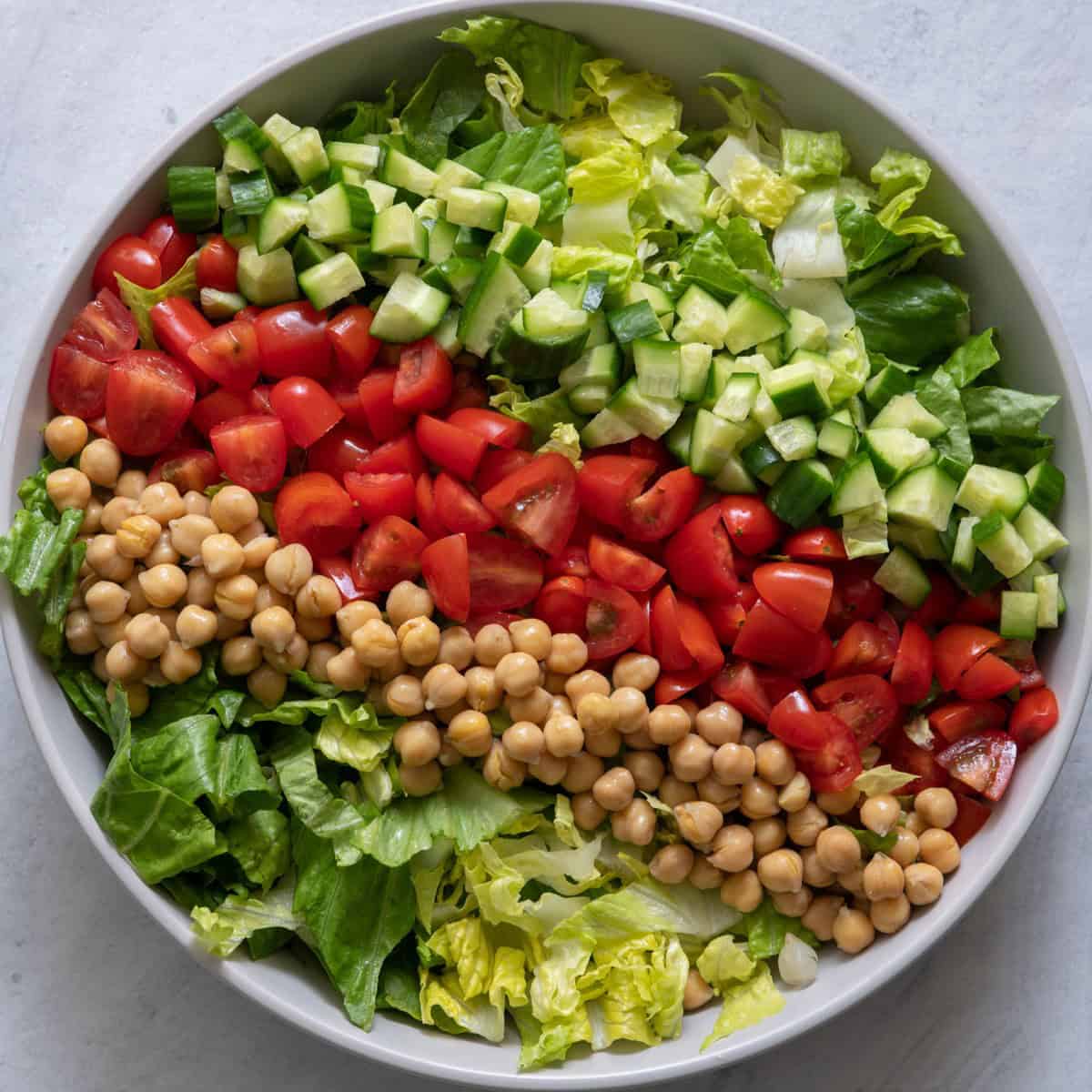Chickpeas and cucumbers added on top of the lettuce.