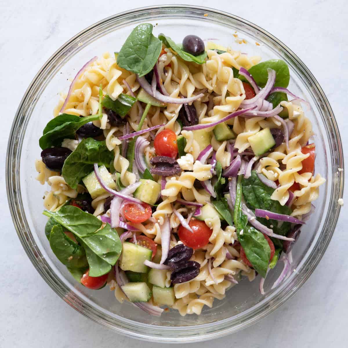 Fully mixed together Mediterranean pasta salad in a large bowl.
