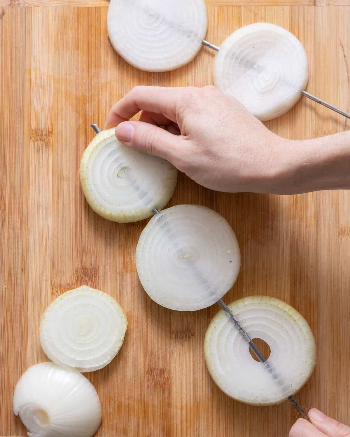 Threading skewer through onion ring.