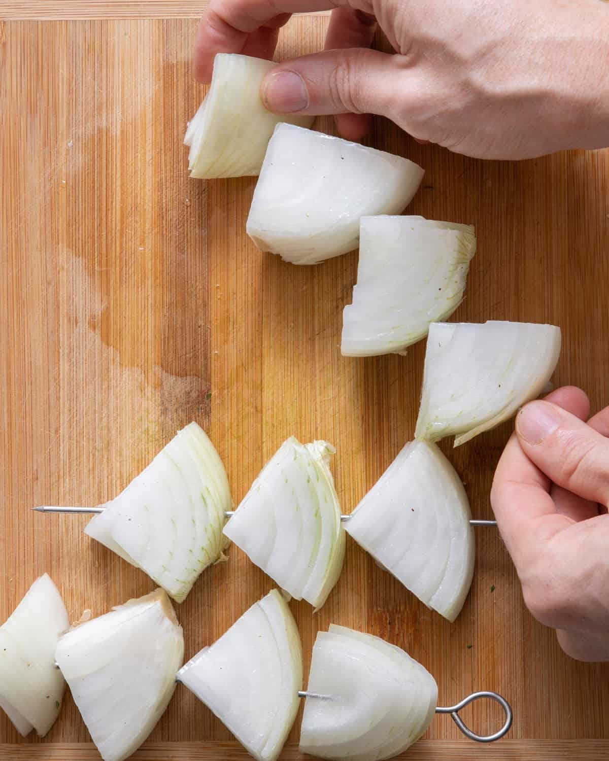 Threading onion chunks through skewer.