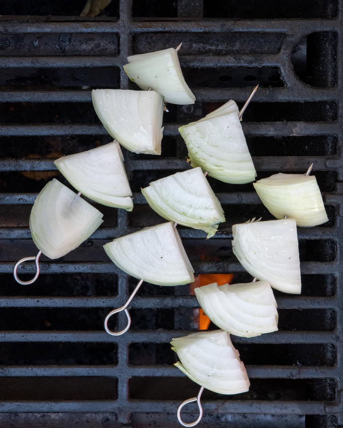 Onion chunks on grill before grilling.