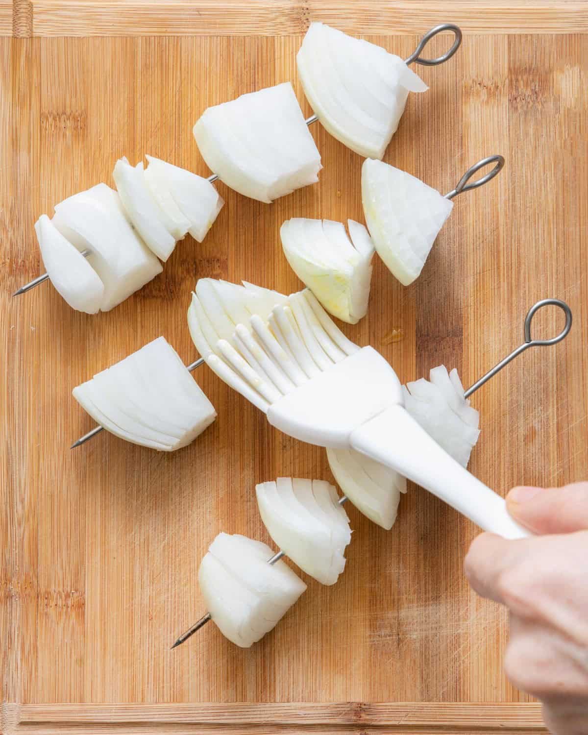 Brushing olive oil, salt and pepper on onion ring.