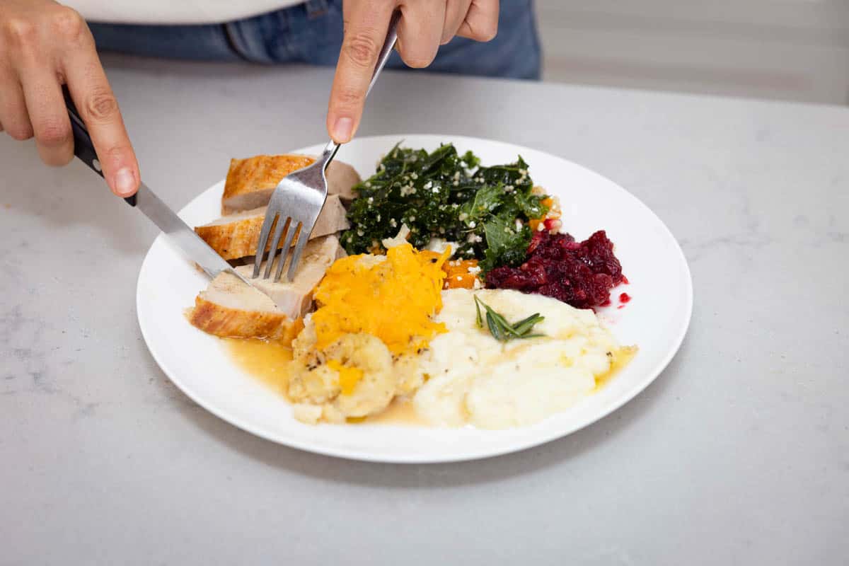 Steak knife cutting turkey on plate