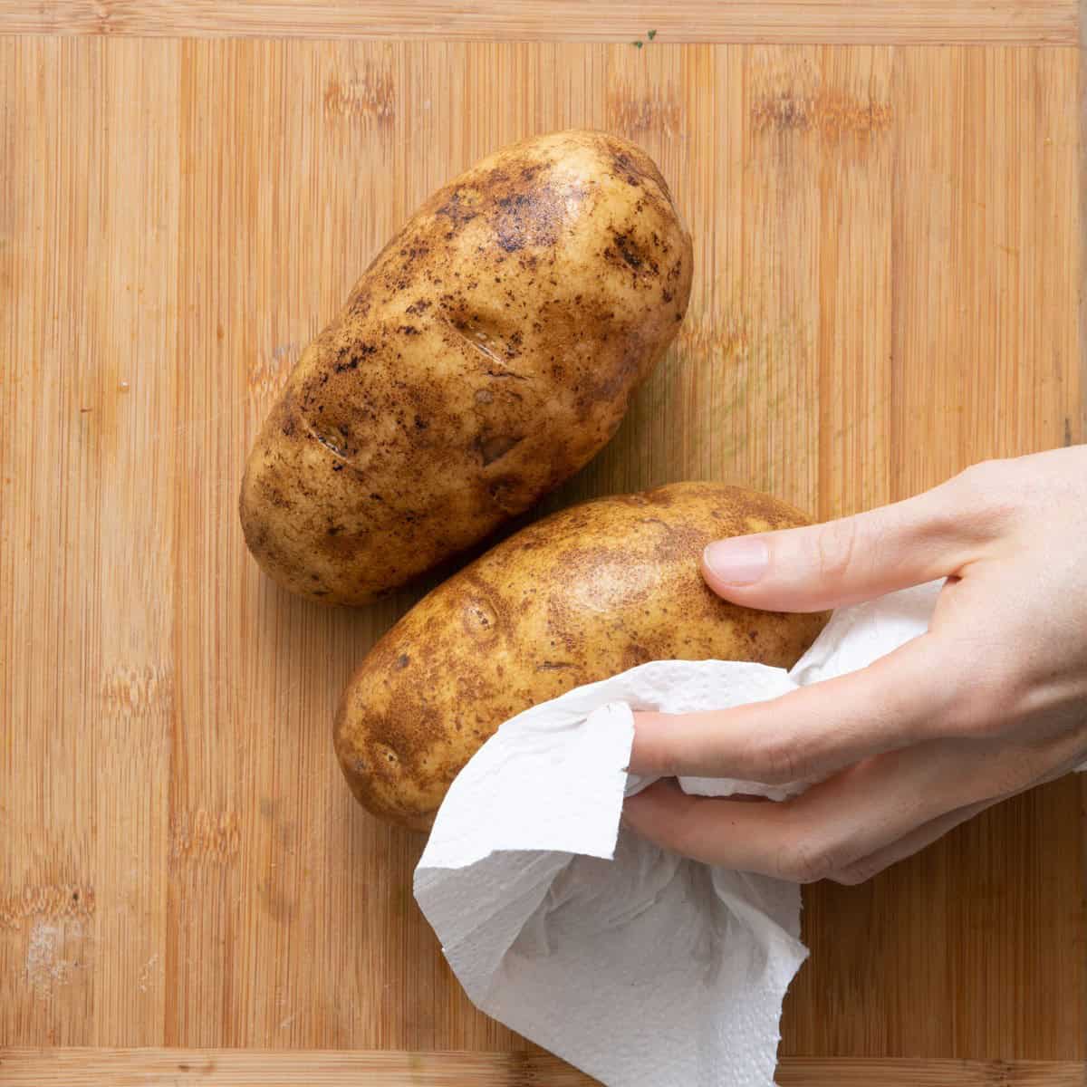Drying wet potatoes with paper towel.