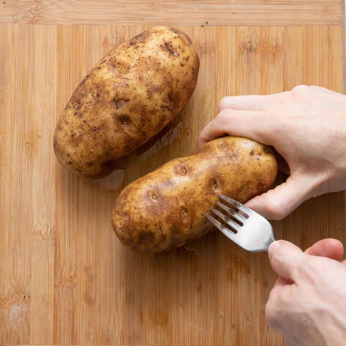 Poking potatoes with fork.