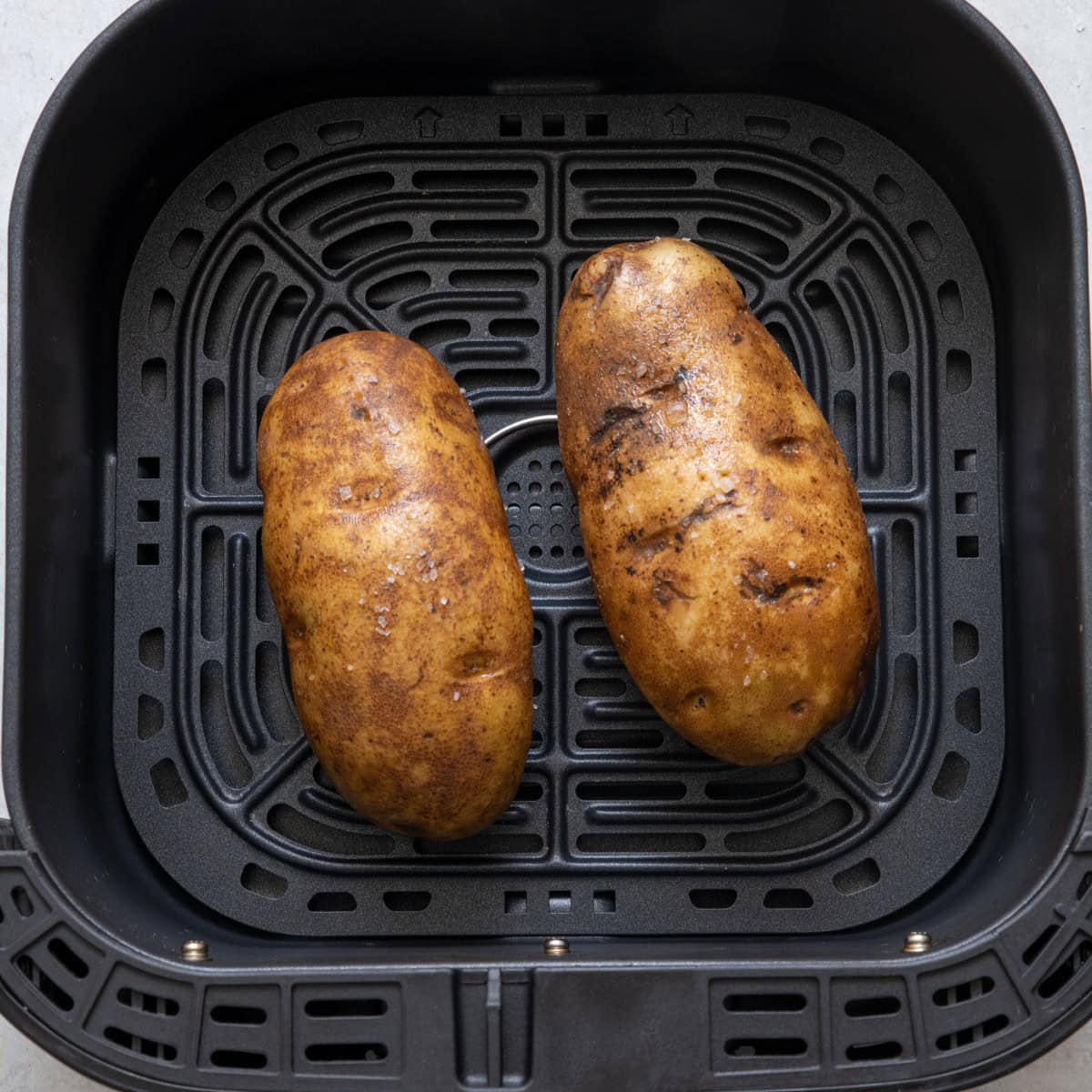 2 potatoes in air fryer before cooked.