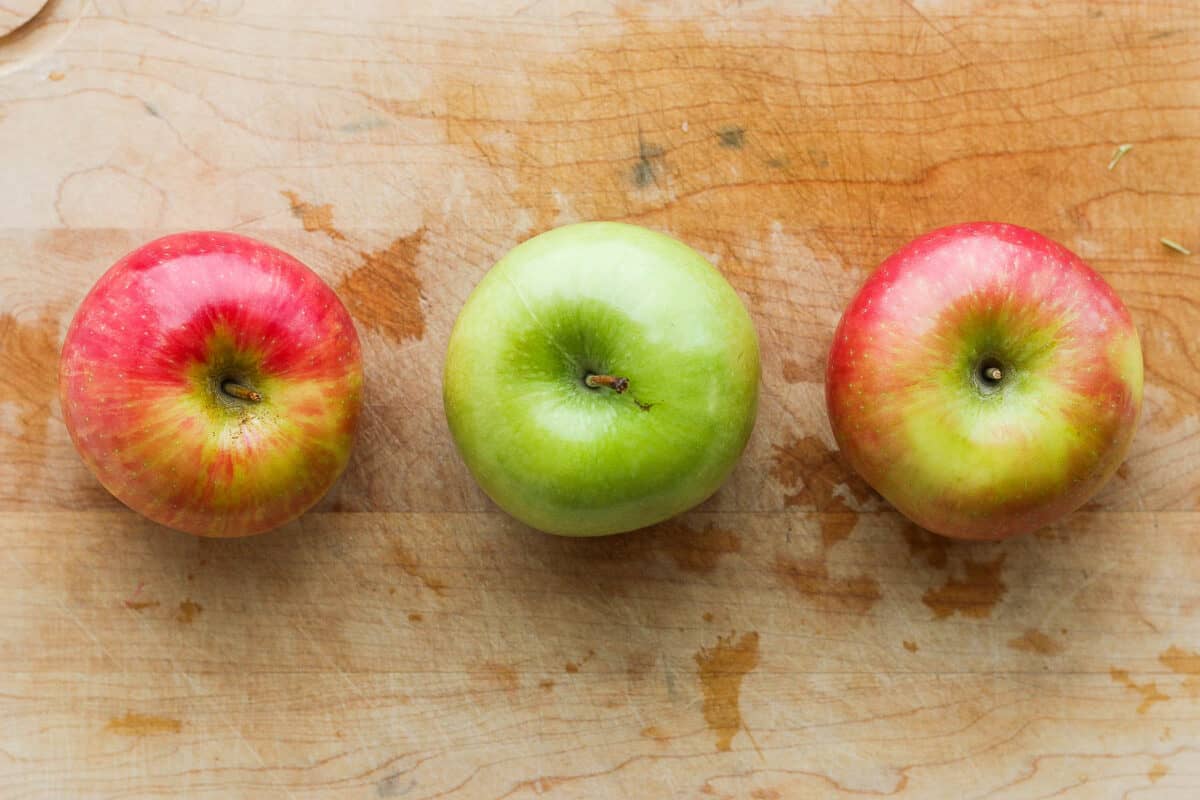 Top down view of 3 different colored whole apples.