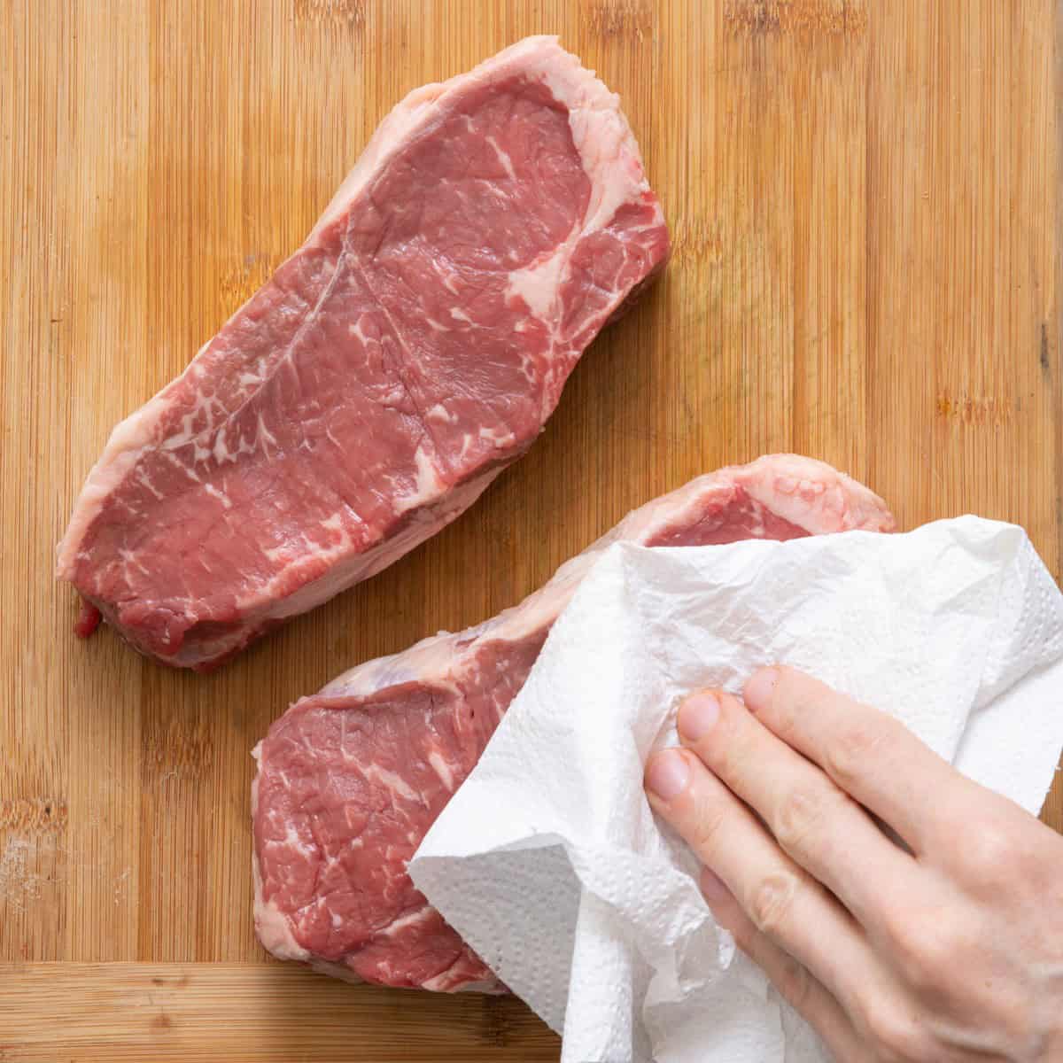 Pat steaks dry.