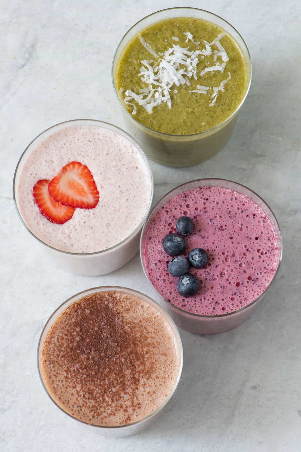 Top down view of 4 different types of freezer recipe in glass cups and garnished.