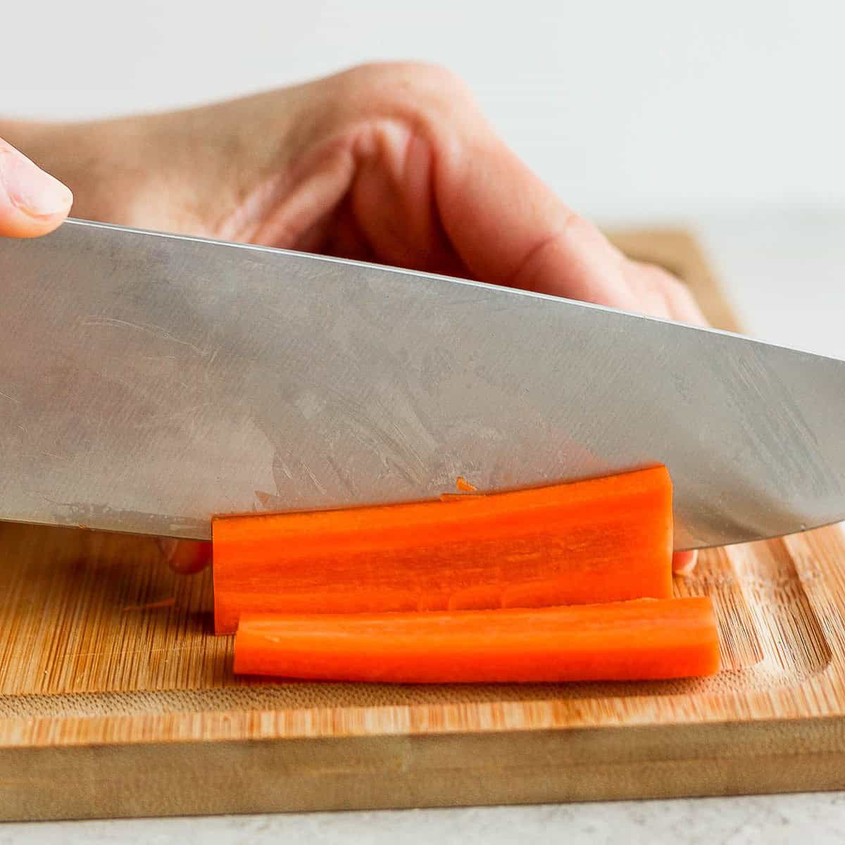 Cutting ยผ inch slabs of carrots.