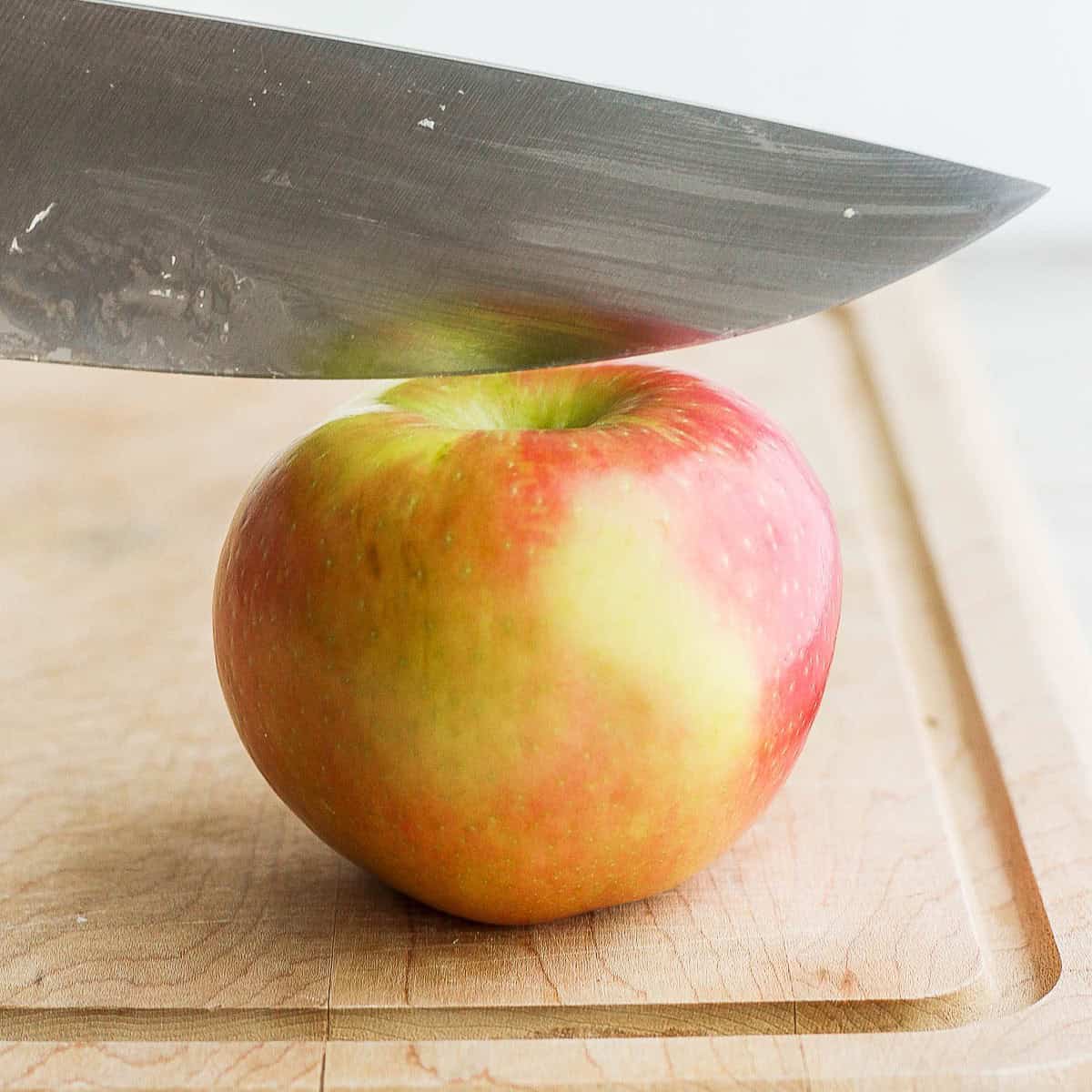 Sharp knife sitting ยผ inch away from stem before cutting.