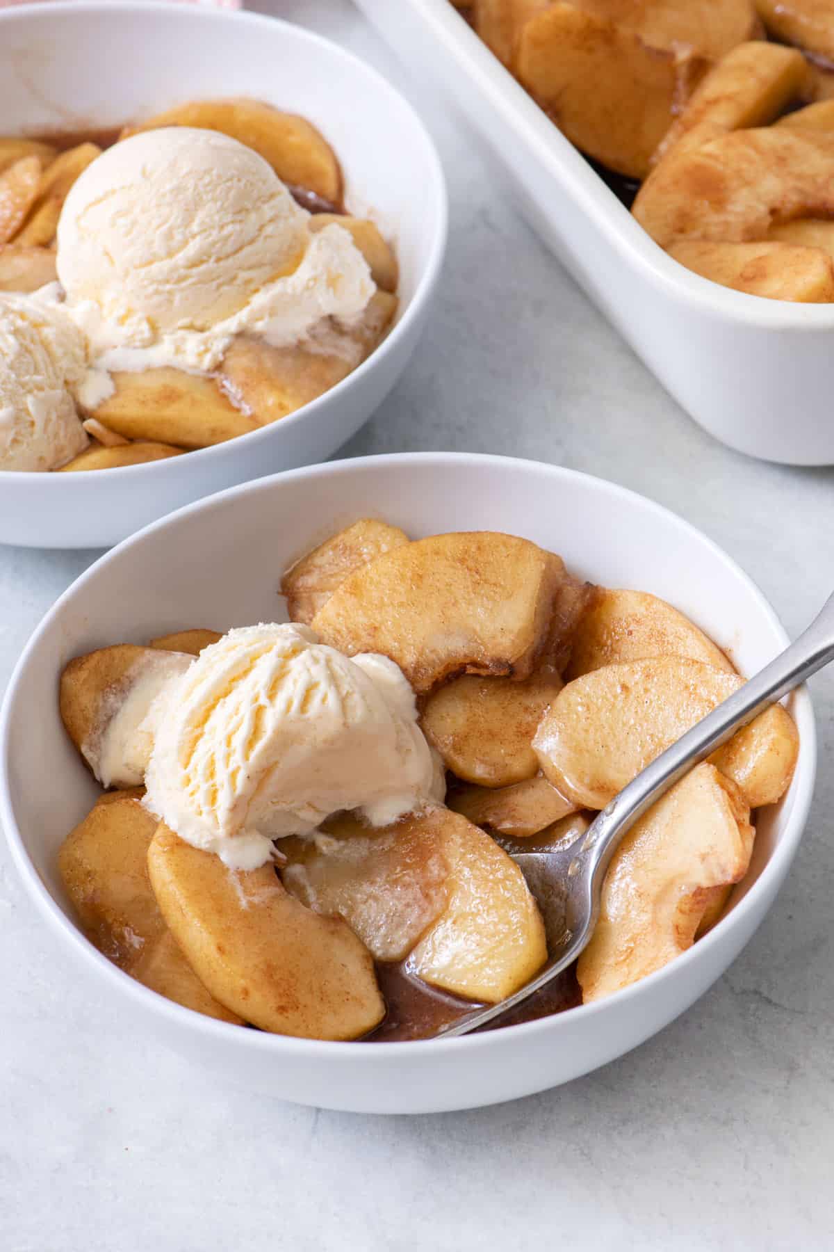 Small bowl of recipe with a spoon dipped in and ice cream on top.