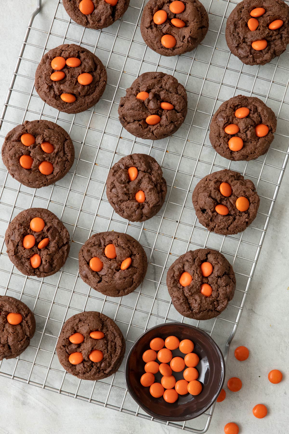 Cookies on a wire rock with small bowl of candy.