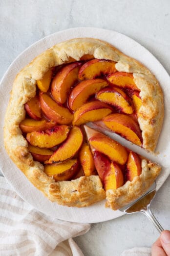 Recipe on a white plate with a slice cut out and a spatula slightly removing it.