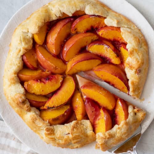 Recipe on a white plate with a slice cut out and a spatula slightly removing it.
