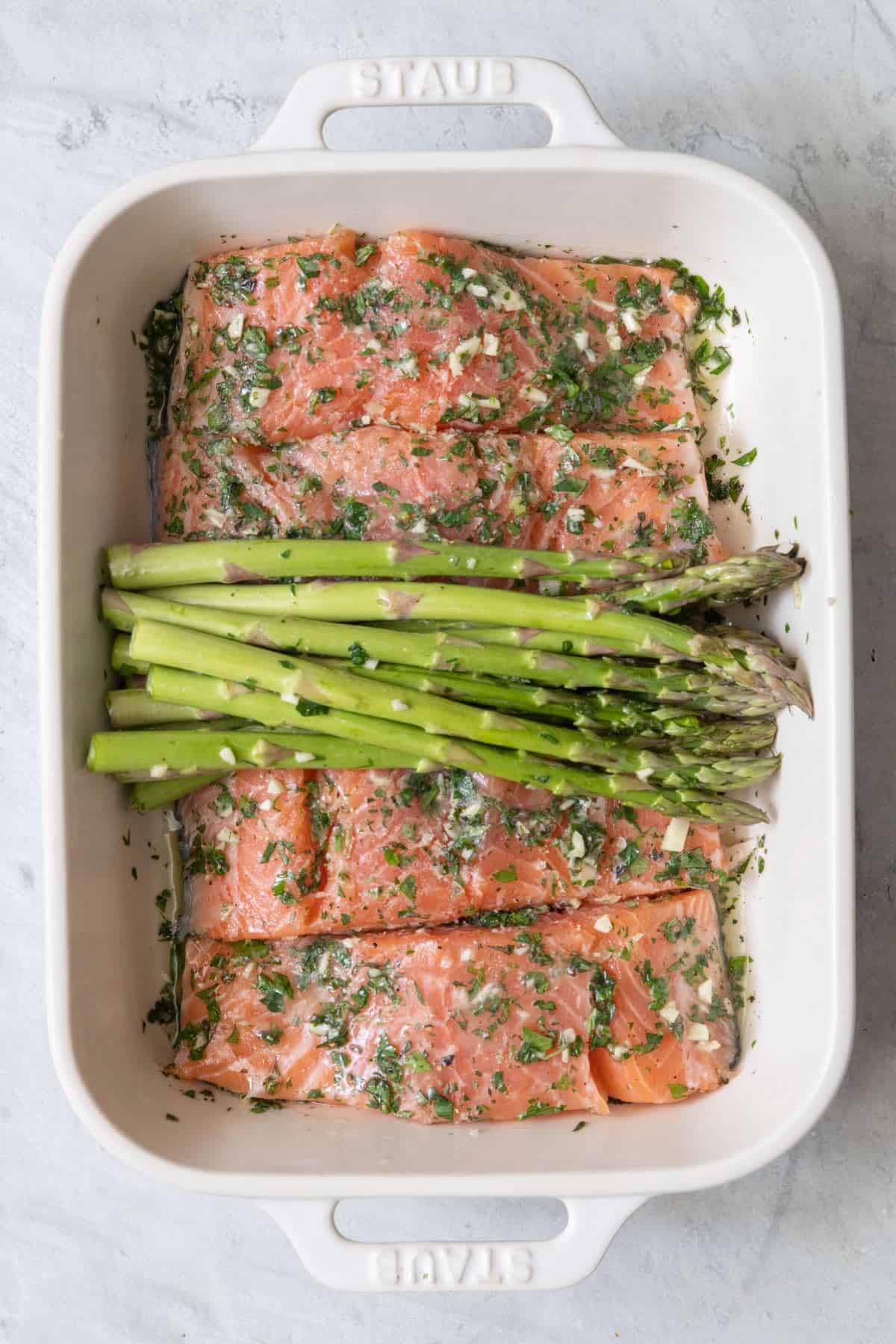 Salmon and asparagus added to the baking dish.