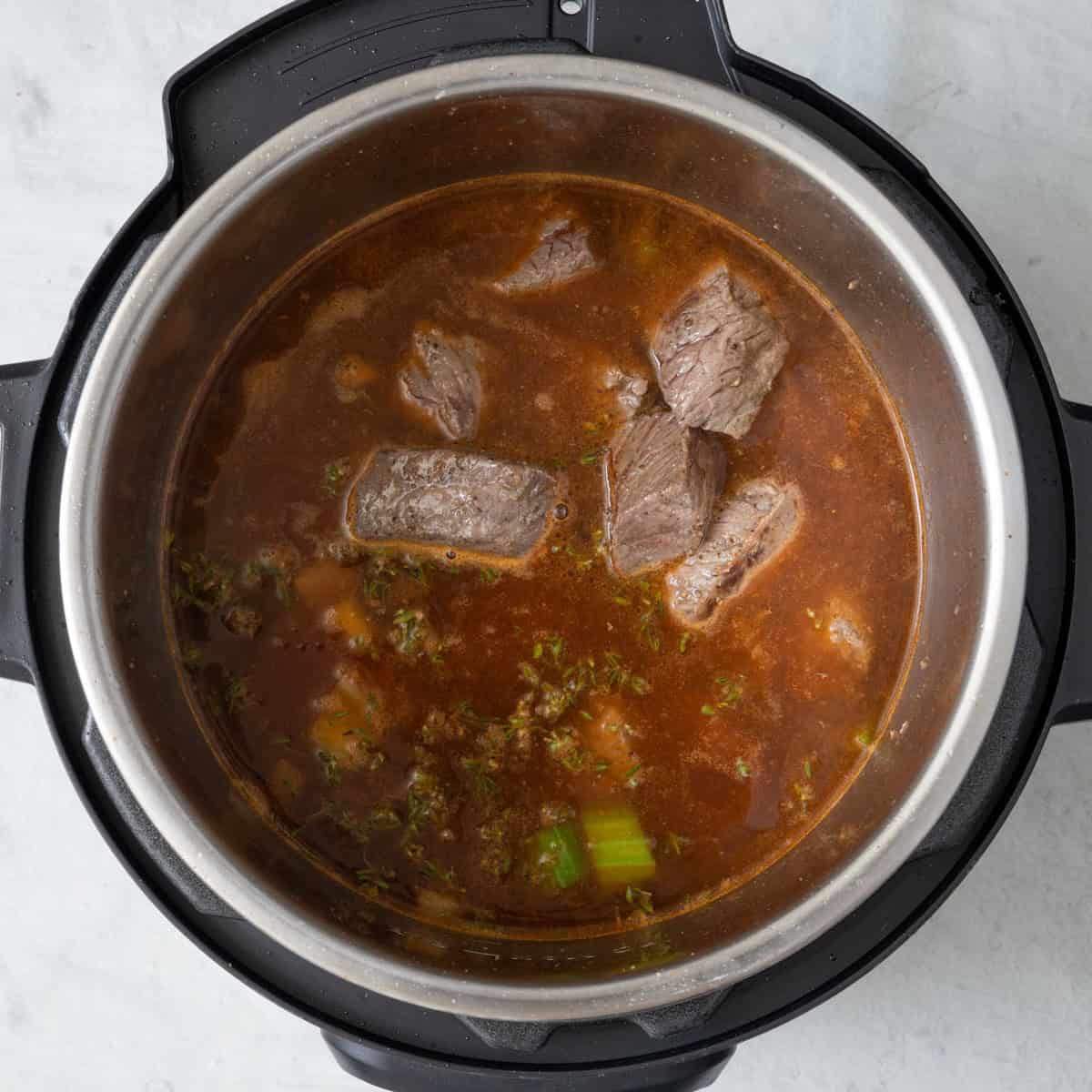 Diced tomatoes, broth and reserved beef added back to pot.