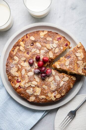 Cake with a slice cut out being lift away from plate.