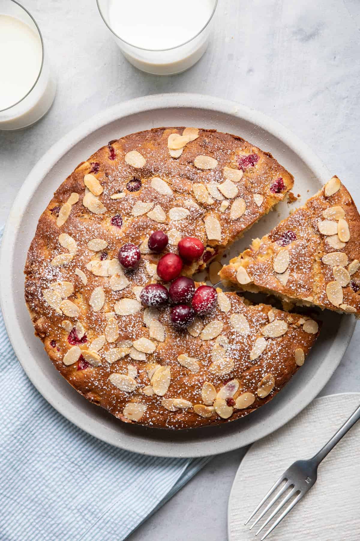 Cake with a slice cut out being lift away from plate.