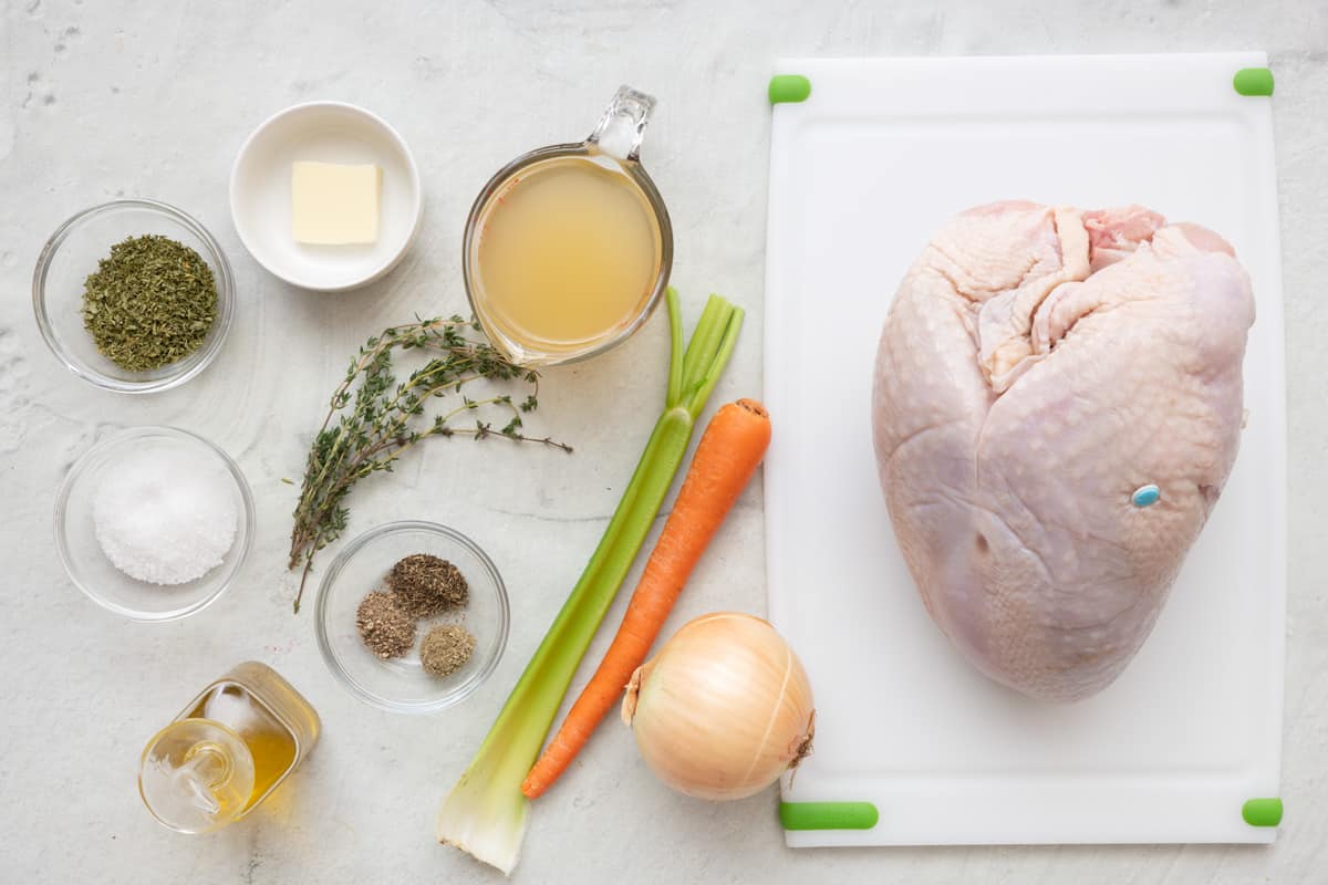 Ingredients for recipe before prepped: dried herbs, salt, butter, fresh herbs, seasonings, opil, broth, celery, carrot, onion, and whole bone in turkey breast.