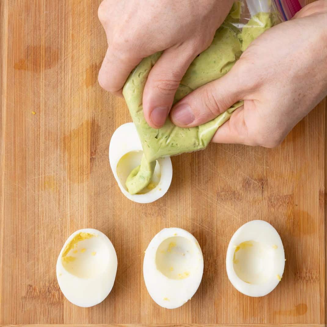 Piping avocado eggs.