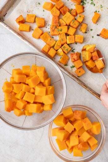 Cooked butternut squash cubes cooked three ways: roasted on a baking sheet, boiled in a strainer, and microwaved in a bowl.