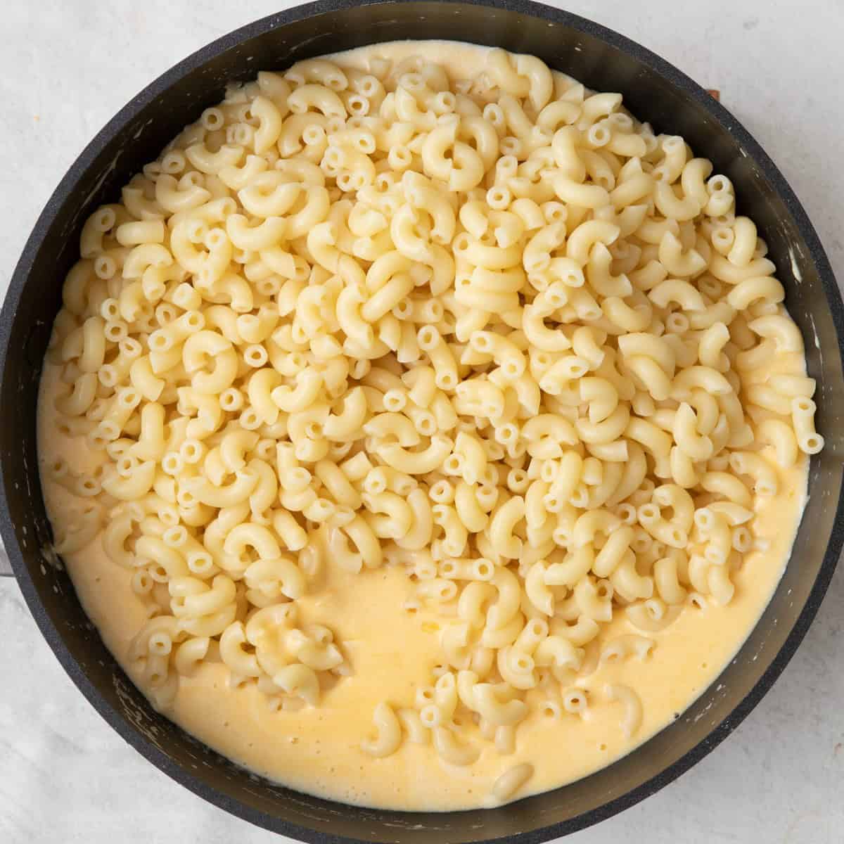 Pasta added on top of mixed sauce.