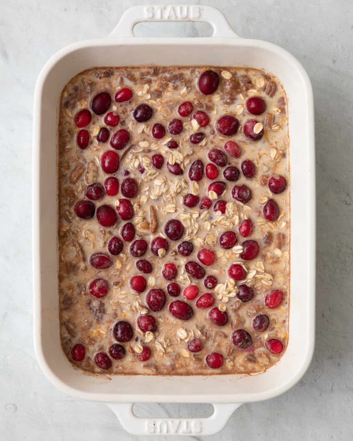 Cranberries fold in and oats covered by wet mixture before baking.