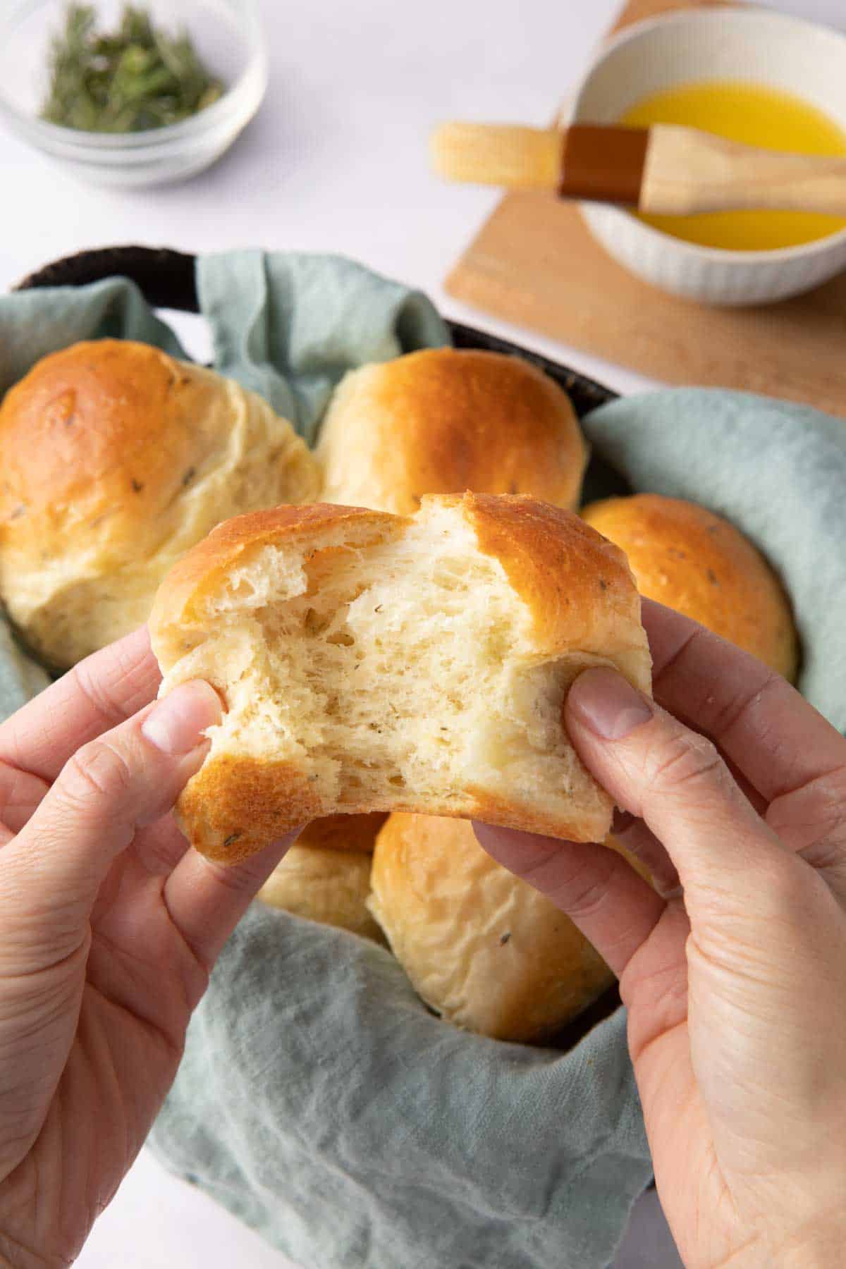 Garlic herb Skillet Dinner Rolls basted with butter in a cast iron skillet with Fleischmannโsยฎ RapidRiseยฎ Instant Yeast pack, fresh sprigs of rosemary, and extra butter and brush nearby.