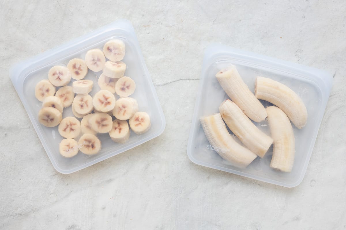2 resealable freezer bags, one with frozen banana slices and the other with frozen banana halves.