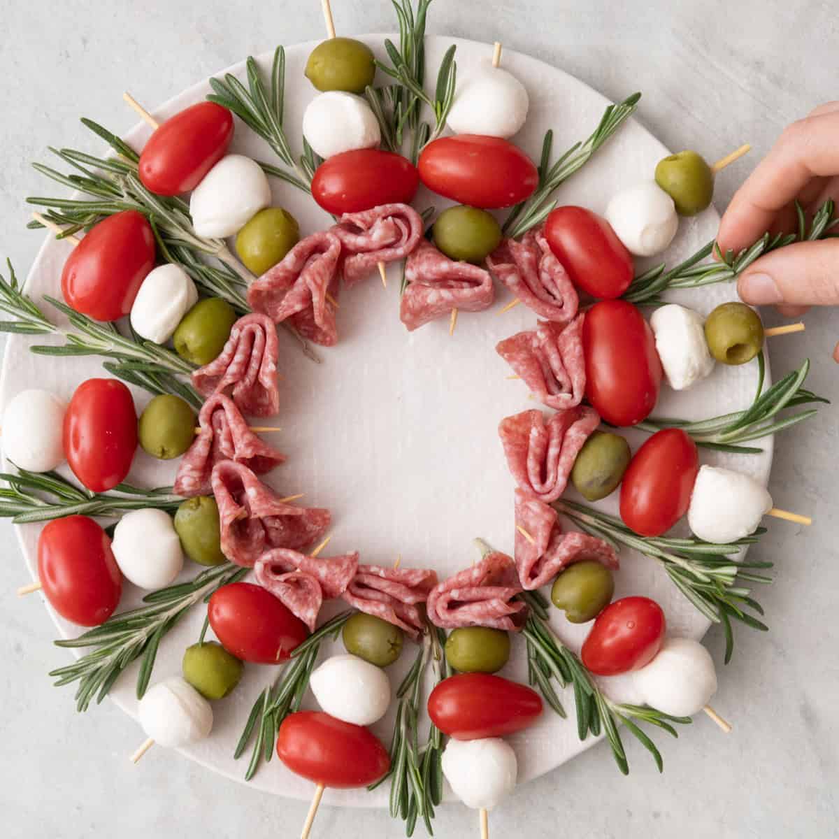 Tucking rosemary underneath some of the skewers.