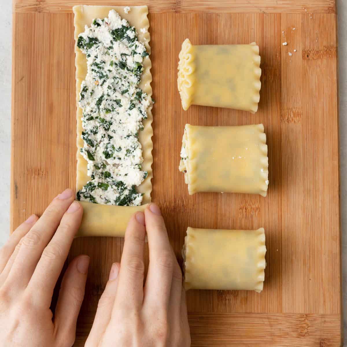 Rolling up one of the lasagna rolls, with a couple rolled up already.